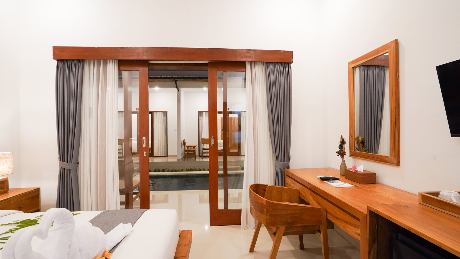 Spacious regular room at Royal Crown Villas with teak furnishings and tropical garden view